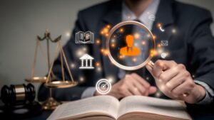 Man in suit holds a magnifying glass over a book with symbols of law and justice.