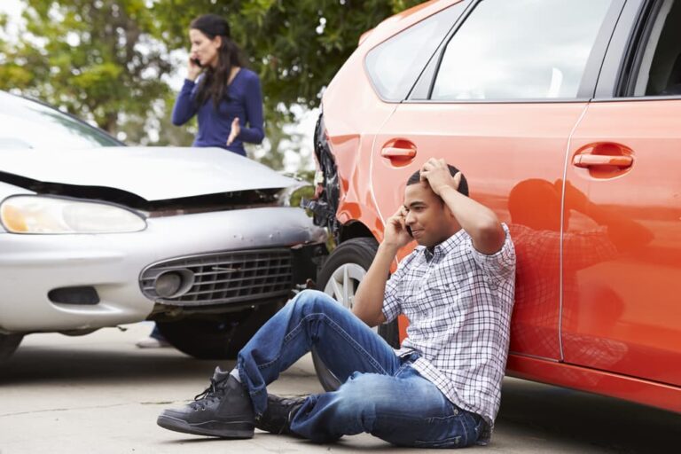 Male and female drivers making phone calls after dangerous car collision.