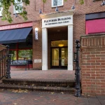 Fletcher Building entrance on Providence Main Street, featuring a barber shop and steps leading to the entrance.