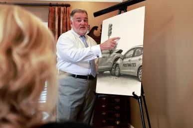 Attorney joel hamner discusses a postmates accident exhibit with a client, reviewing gps and delivery logs.