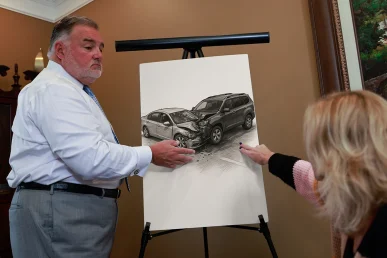 Attorney joel hamner discusses a t bone accident exhibit with a client, showing intersection signal evidence.