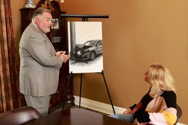 Attorney joel hamner discusses a catastrophic injury exhibit with a client, outlining long term medical needs.