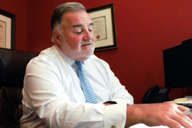 Attorney joel hamner discusses a crane accident exhibit with a client, showing rigging failure analysis.