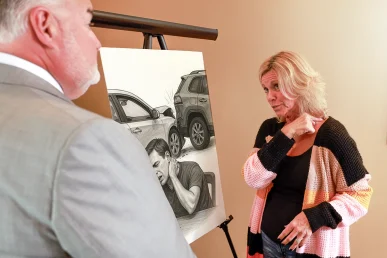Attorney joel hamner discusses a neck injury exhibit with a client, focusing on diagnostic images.