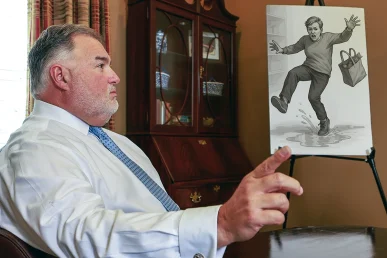 Attorney joel hamner discusses a slip and fall accident exhibit with a client, pointing to security camera stills.