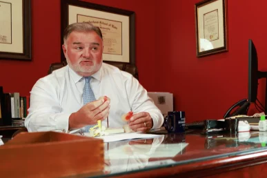 Attorney joel hamner discusses a spinal cord injury exhibit with a client, highlighting mri evidence.