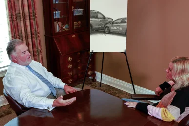 Attorney joel hamner discusses an instacart accident exhibit with a client, including delivery route maps.