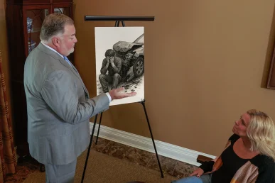 Attorney joel hamner discusses an emotional distress exhibit with a client, showing psychological evaluation notes.