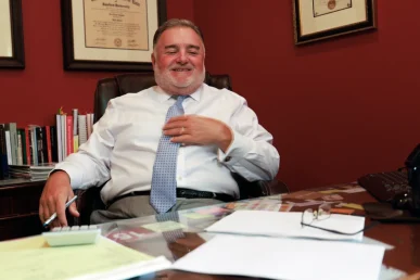 Attorney joel hamner explains a dhl accident exhibit to a client, focusing on delivery route logs.