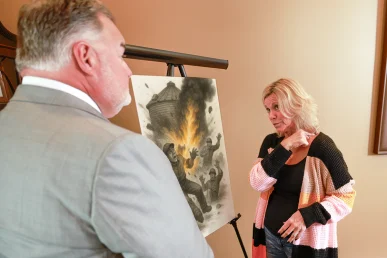 Attorney joel hamner explains a grain bin explosion exhibit to a client, presenting blast pattern evidence.
