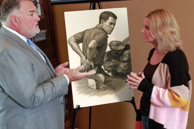Attorney joel hamner explains a lumbar injury exhibit to a client, showing mri scans and therapy schedules.