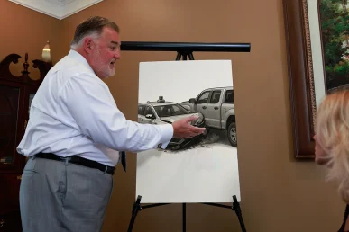 Attorney joel hamner explains a self driving vehicle accident exhibit to a client, showing sensor data timelines.