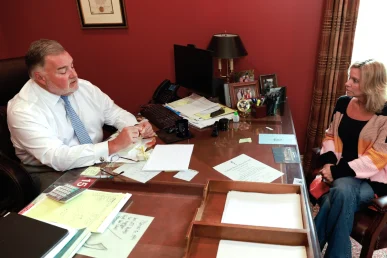 Attorney joel hamner explains a talcum powder injury exhibit to a client, featuring product testing data.