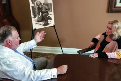 Attorney joel hamner explains a toxic exposure exhibit to a client, mapping contamination sites and lab findings.