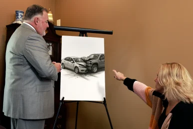 Attorney joel hamner explains an uninsured driver accident exhibit to a client, focusing on coverage gaps.