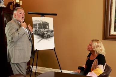 Attorney joel hamner goes over a bus accident exhibit with a client, covering route maps and collision diagrams.