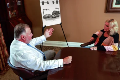 Attorney joel hamner meets with a client to discuss an intersection accident exhibit showing traffic signal timing.