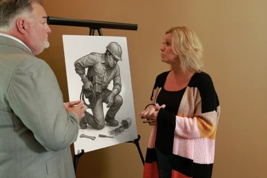 Attorney joel hamner meets with a client to examine a joint injury exhibit featuring medical imaging.