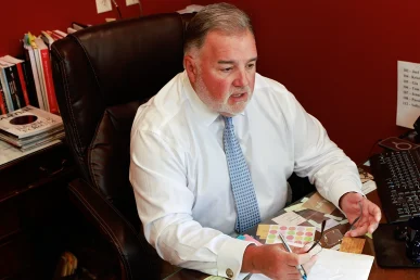 Attorney joel hamner meets with a client to review a bone fracture exhibit with x ray evidence.