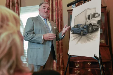Attorney joel hamner meets with a client to review a delivery truck accident exhibit with gps and crash scene evidence.