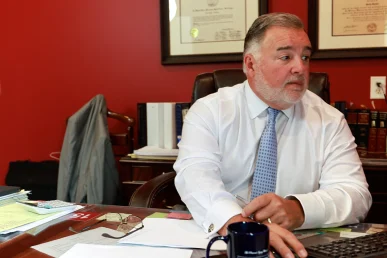 Attorney joel hamner meets with a client to review a water contamination exhibit highlighting lab results.