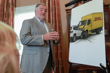 Attorney joel hamner presents a dhl accident exhibit to a client, covering delivery route data and witness reports.