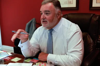 Attorney joel hamner presents a brain injury exhibit to a client, focusing on neurological imaging.