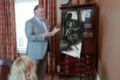 Attorney joel hamner presents a defective car seat exhibit to a client, focusing on recall evidence.