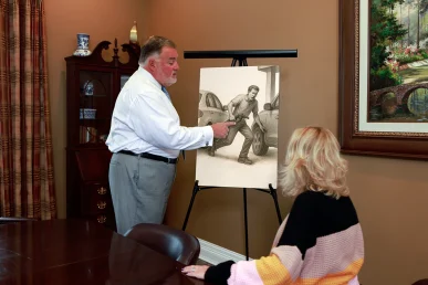 Attorney joel hamner presents a runaway vehicle accident exhibit to a client, detailing brake failure findings.