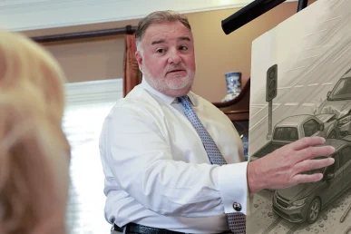 Attorney joel hamner presents a traffic accident exhibit to a client, summarizing roadway hazards.