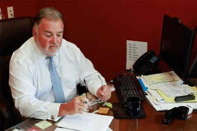 Attorney joel hamner reviews a back injury exhibit with a client, pointing out mri scans.