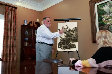Attorney joel hamner reviews a paralysis injury exhibit with a client, focusing on spinal cord data.