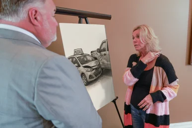 Attorney joel hamner reviews a pizza delivery accident exhibit with a client, showing gps route evidence.