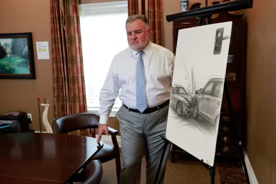 Attorney joel hamner reviews a reckless driving exhibit with a client, showing speed tracking evidence.
