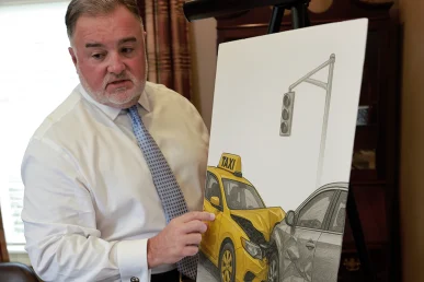 Attorney joel hamner reviews a taxi accident exhibit with a client, covering driver logs and witness statements.