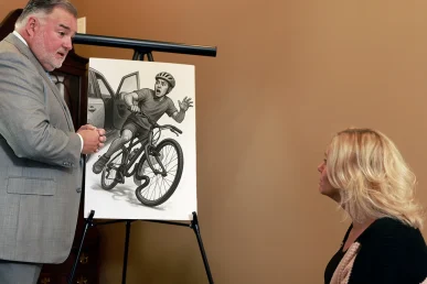 Attorney joel hamner reviews a workplace accident exhibit with a client, outlining safety procedure failures.