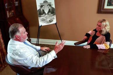 Attorney joel hamner reviews an insurance bad faith exhibit with a client, detailing claim denial evidence.