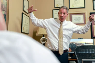 Attorneys joel hamner and tom mccutcheon discuss a hit and run accident claim with a client.