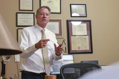 Attorneys joel hamner and tom mccutcheon discuss an elevator accident case with a client.