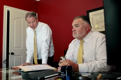 Attorneys tom mccutcheon and joel hamner consult with a client about a pizza delivery accident claim.