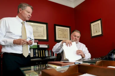 Attorneys tom mccutcheon and joel hamner discuss a ups delivery accident case with a client.