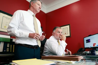 Attorneys tom mccutcheon and joel hamner meet with a client to discuss a restaurant related food poisoning claim.