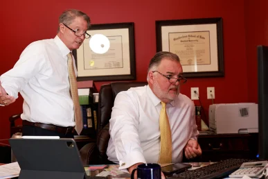 Attorneys tom mccutcheon and joel hamner review medical imaging with a client considering a brain injury lawsuit.