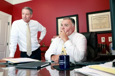 Attorneys tom mccutcheon and joel hamner review medical scans with a client for a lumbar injury claim.
