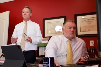 Attorneys tom mccutcheon and joel hamner talk through treatment records with a client pursuing a burn injury claim.