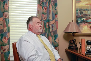 Joel hamner and tom mccutcheon sit with a client in tom’s office to examine an automotive defects lawsuit.