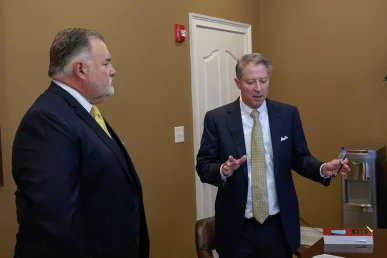 Joel hamner and attorney tom mccutcheon discuss legal strategies for an off road vehicle collision case during a detailed consultation.