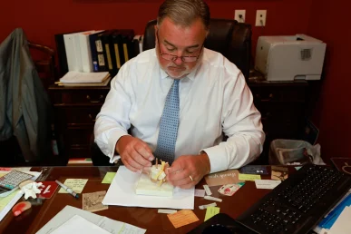 Lawyer joel hamner discusses a defective car seat exhibit with a client, focusing on product failure evidence.