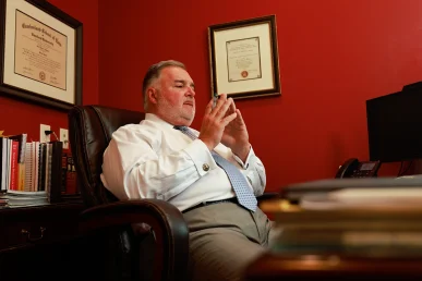 Lawyer joel hamner discusses a golf cart accident exhibit with a client, highlighting course safety issues.