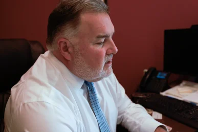Lawyer joel hamner discusses a heavy machinery accident exhibit with a client, highlighting equipment failure analysis.